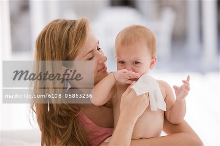 Woman wiping her daughter's blowing nose