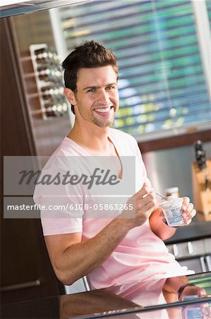 Man eating yogurt in the kitchen