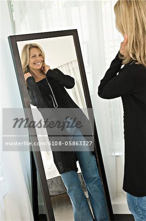 Woman trying on a dress in front of a mirror