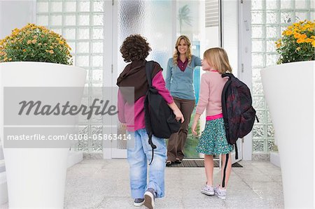 Woman with her children at the entrance door of a house