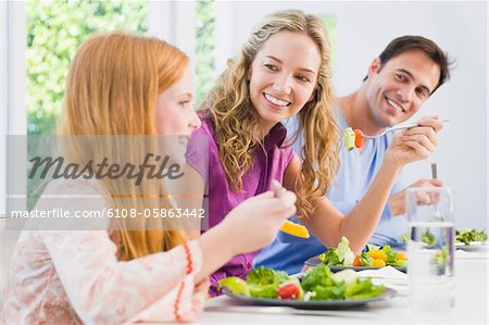 Mädchen mit ihren Eltern am Esstisch