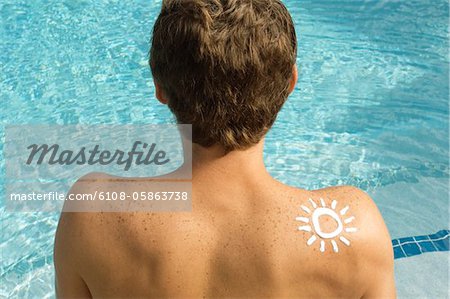 Man with sun shape on his shoulder at the poolside