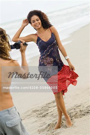 Homme faire une vidéo d'une femme sur la plage