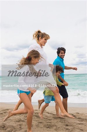 Family running on the beach