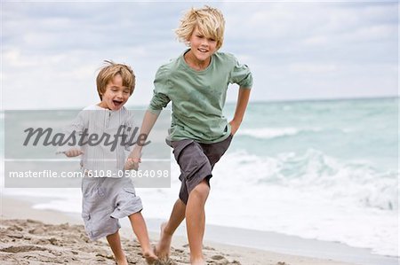 Two boys running on the beach