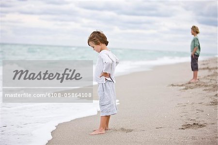 Two boys standing on the beach