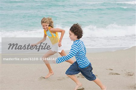 Boy running with a girl on the beach