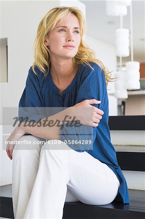Femme assise sur les marches et la pensée