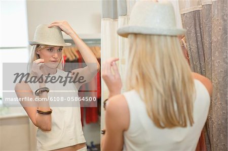 Woman trying on a fedora in a boutique