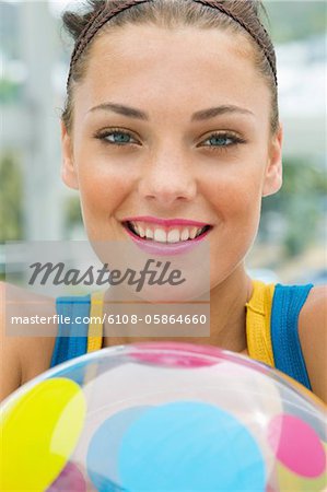 Frau hält ein Strandball und Lächeln