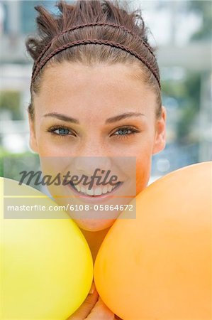 Woman holding balloons and smiling