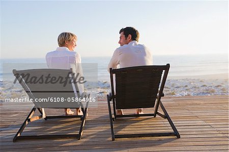 Paar, sitzen auf den Liegestühlen am Strand