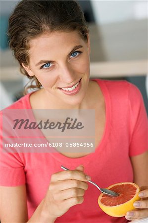 Portrait of a woman eating grapefruit