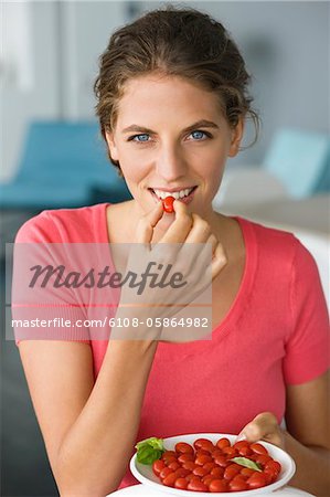 Portrait d'une femme qui mange des tomates italiennes