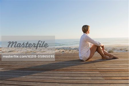 Femme assise sur un trottoir de bois