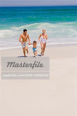 Family running on the beach