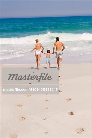 Family running on the beach