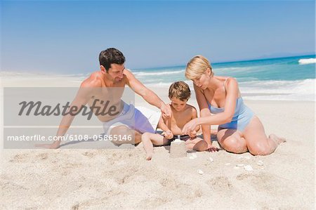 Familie machen eine Sandburg am Strand