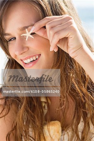 Woman showing a starfish and smiling