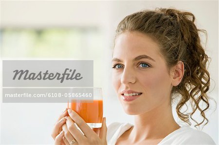 Woman holding a glass of tomato soup