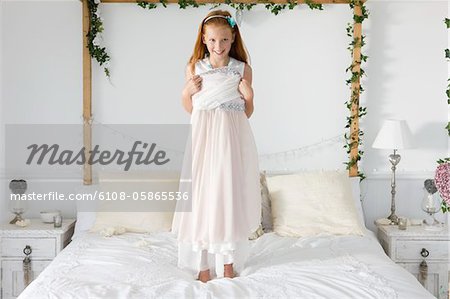 Portrait of a girl standing on the bed
