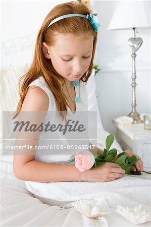 Mädchen mit eine Blume auf dem Bett