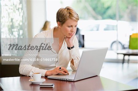 Geschäftsfrau, die auf einem Laptop in einem Restaurant arbeiten