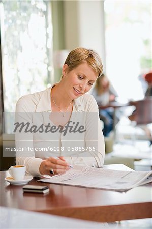 Geschäftsfrau, sitzen in einem Restaurant und einer Wirtschaftszeitung lesen