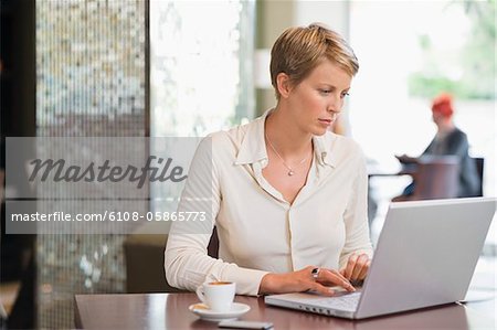 Femme d'affaires travaillant sur un ordinateur portable dans un restaurant