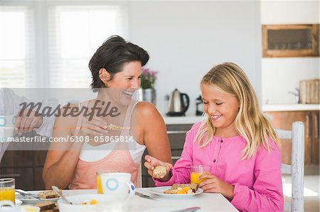 Frau frühstücken mit ihrer Tochter am Esstisch