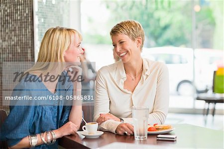 Deux femmes, assis dans un restaurant et souriant