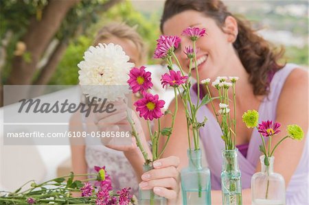Frau mit ihrer Tochter anordnen von Blumen in einer vase