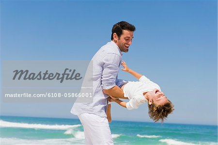 Homme qui joue avec son fils sur la plage