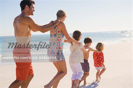 Family walking on the beach in train formation