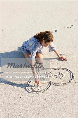 Frau Zeichnen einer Herzform am Strand