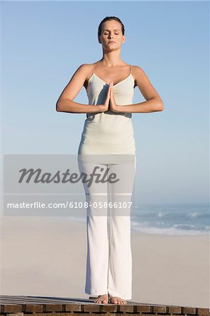 Frau praktizieren Yoga auf einer Promenade