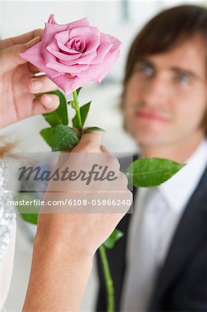 Frau hält eine Blume vor einem Mann