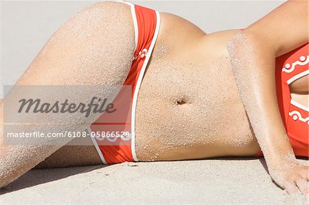Mid section view of a woman lying on the beach