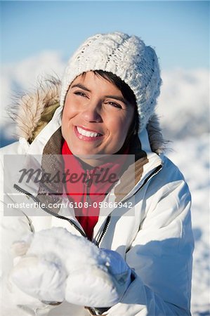 Young smiling woman holding snow