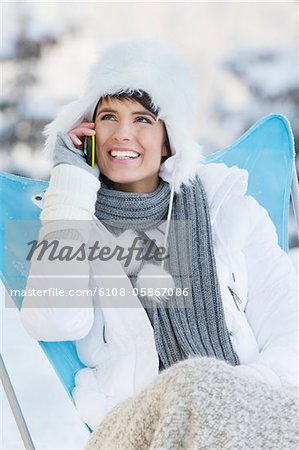 Junge Frau mit Handy im Schnee