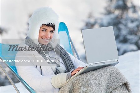 Junge Frau mit Laptop-Computer im Schnee