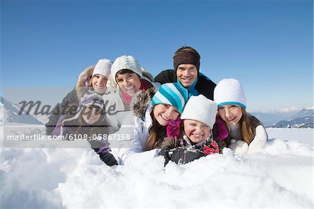 Glückliche Familie im Schnee liegend