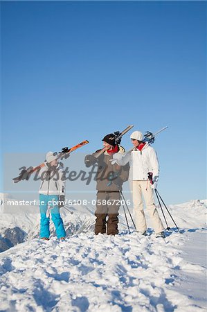 Couple and daughter carrying skis