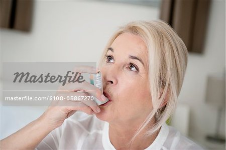Gros plan d'une femme à l'aide d'un inhalateur asthme