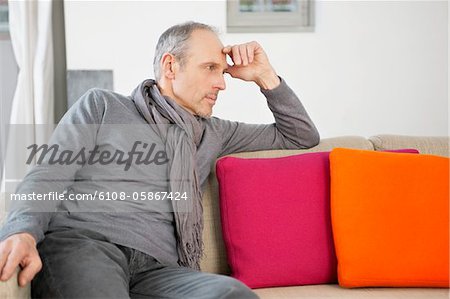 Man sitting on a couch and thinking