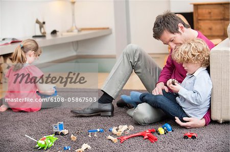 Mann spielt mit seinem Sohn in einem Wohnzimmer