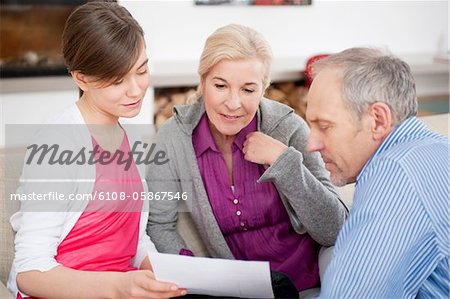 Jeune fille lisant un document avec ses grands-parents