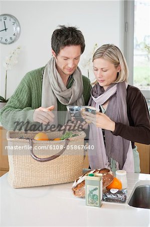 Couple vérification des produits d'épicerie à la maison
