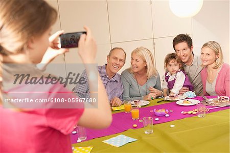 Girl taking a picture of her family with a camera phone