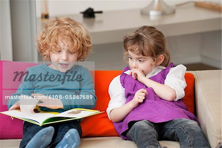 Garçon assis avec sa sœur et lire un bon livre